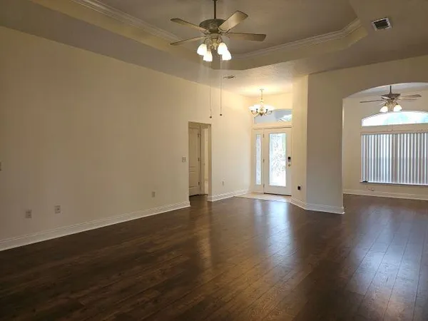 a view of an empty room with window and wooden floor