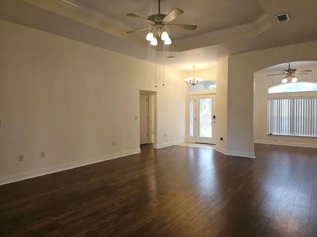 a view of an empty room with window and wooden floor