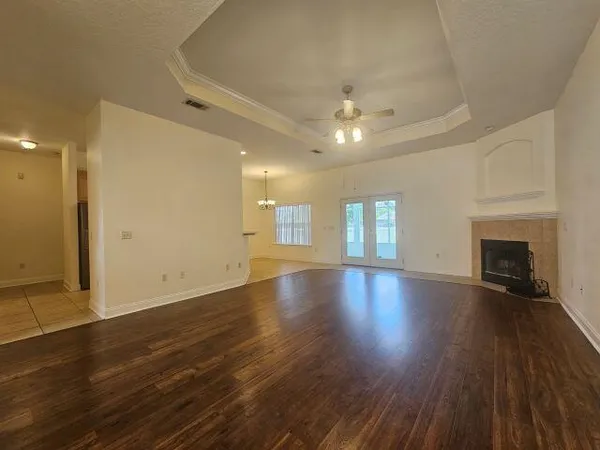 an empty room with wooden floor and fireplace