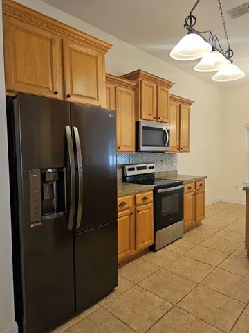 a kitchen with stainless steel appliances granite countertop a refrigerator stove and microwave