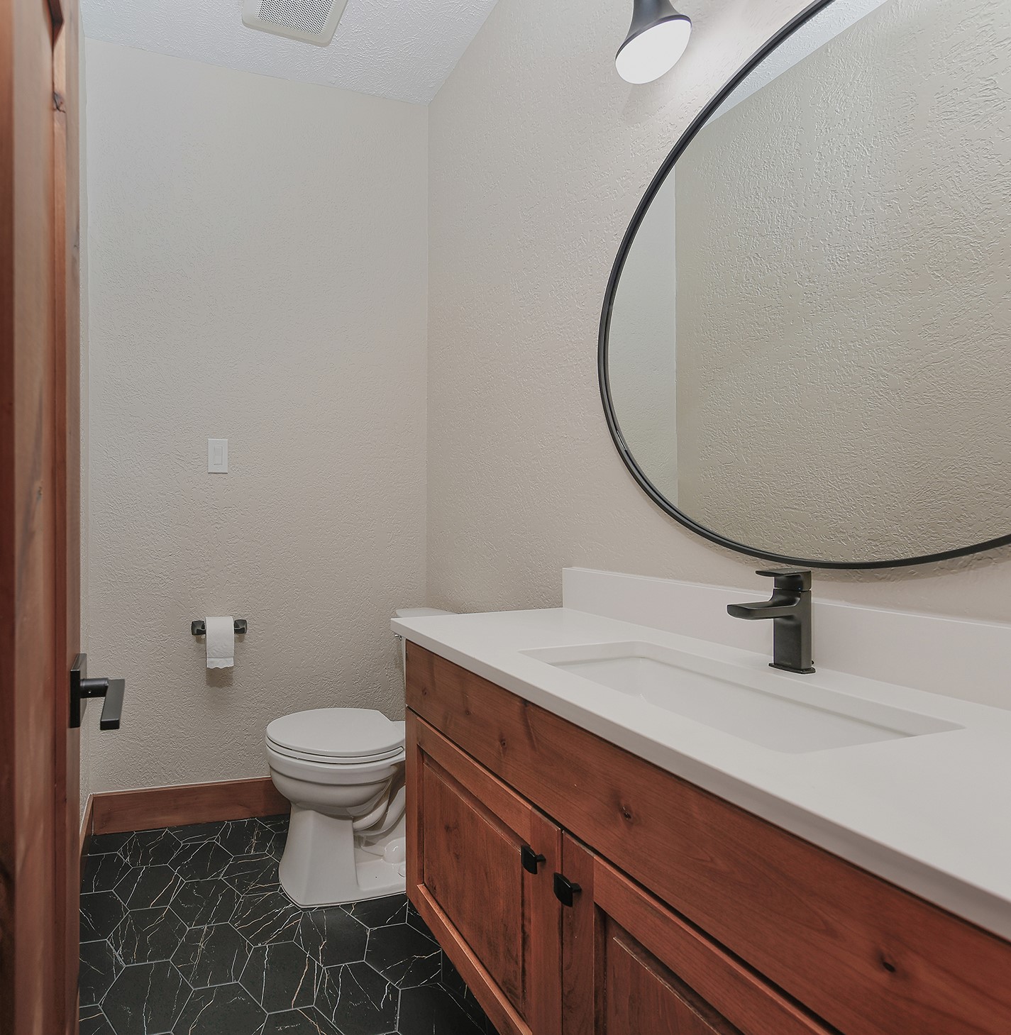 26442 McDonald Road Spring, TX 77380 - Photo 35 of 50 Powder Bath 2 has fabulous black octagon tile floors with modern custom vanity, quartz counter, and eye-catching black lighting/plumbing fixtures.