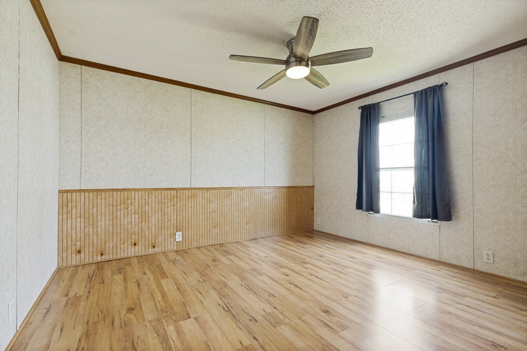 207 Vivian Road Onalaska, TX 77360 - Photo 28 of 34 an empty room with wooden floor fan and windows