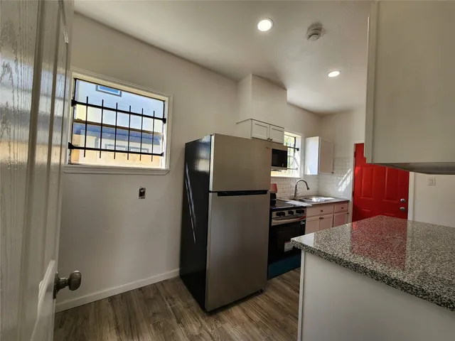 a kitchen with granite countertop a refrigerator and a sink