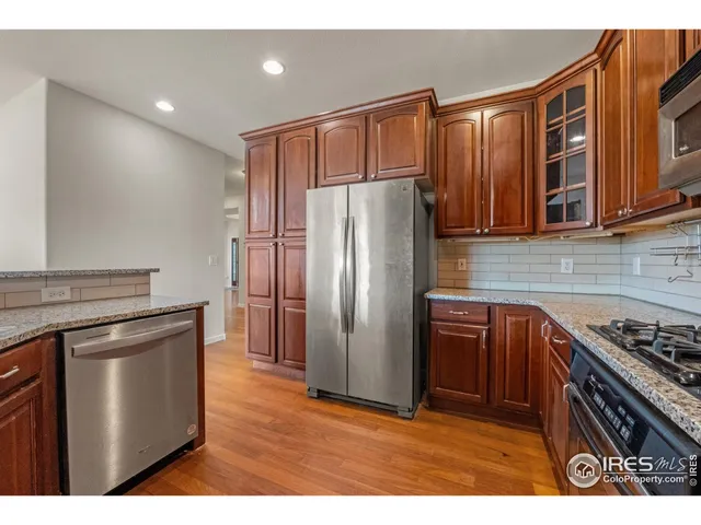 a kitchen with stainless steel appliances granite countertop a refrigerator a stove and a sink