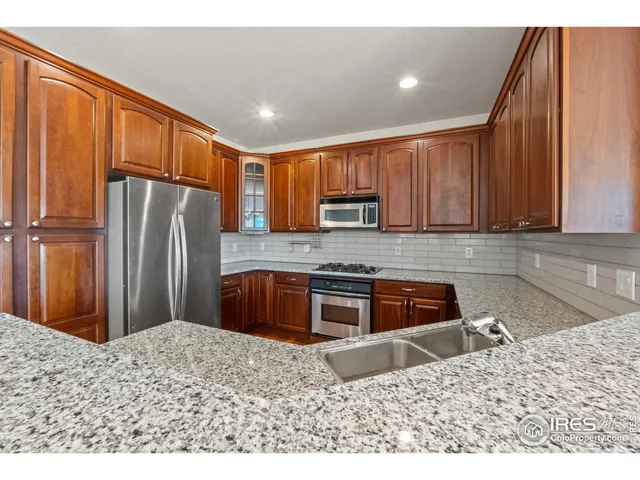 a kitchen with a refrigerator sink and cabinets