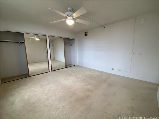 an empty room with a ceiling fan and shower