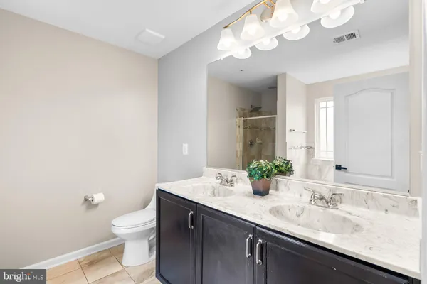 a bathroom with a granite countertop sink a toilet and a mirror