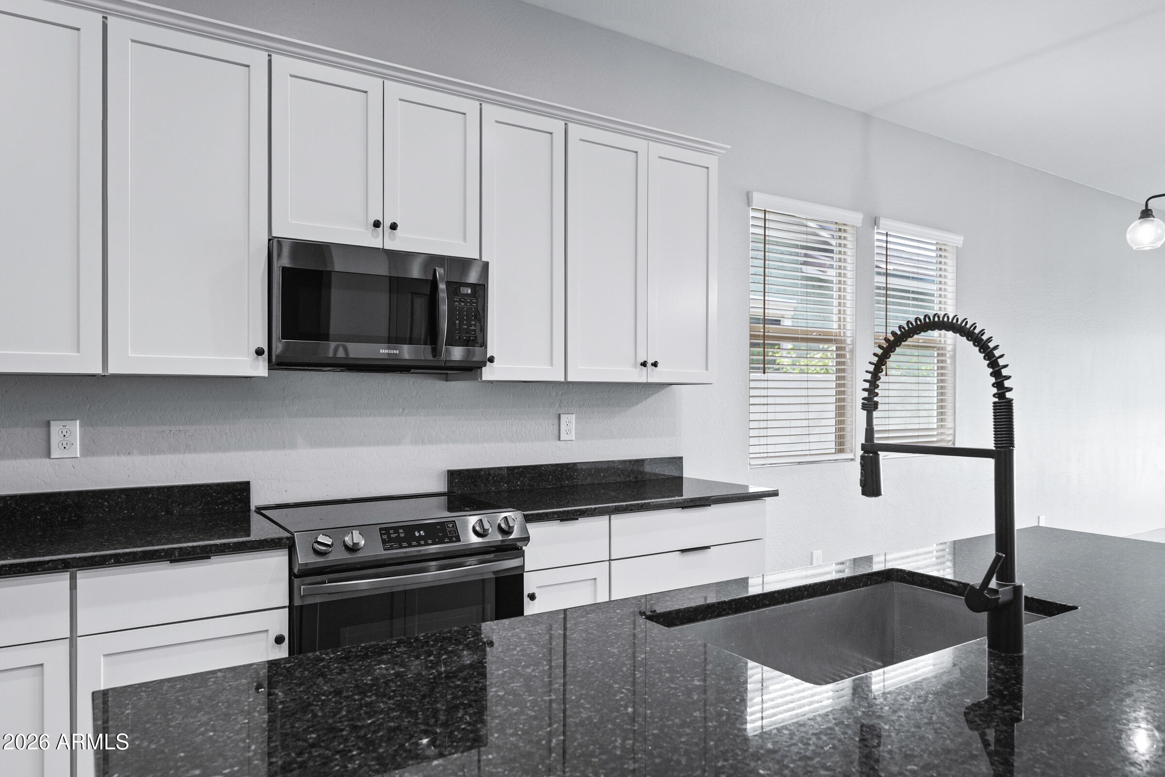 3900 East Appaloosa Road Gilbert, AZ 85296 - Photo 8 of 38 a kitchen with granite countertop a stove and a sink