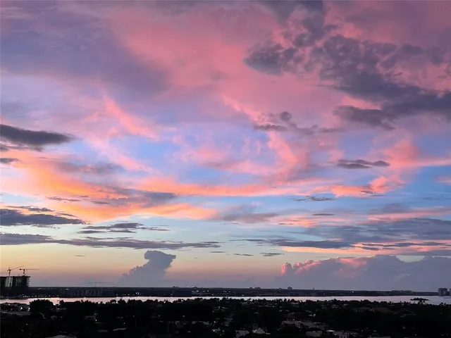 a kitchen with stainless steel appliances a refrigerator a sink a stove a microwave a sink a refrigerator white cabinets and wooden floor