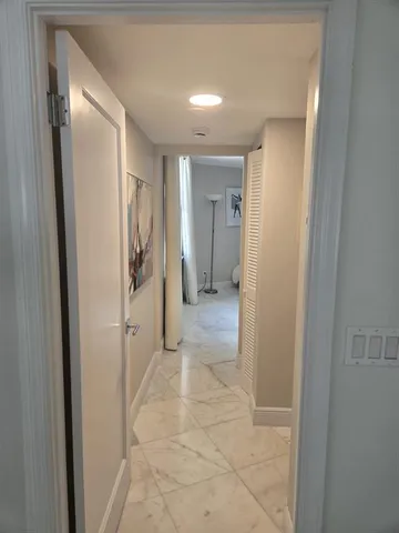 a large white kitchen with a sink and dishwasher a stove top oven with wooden floor