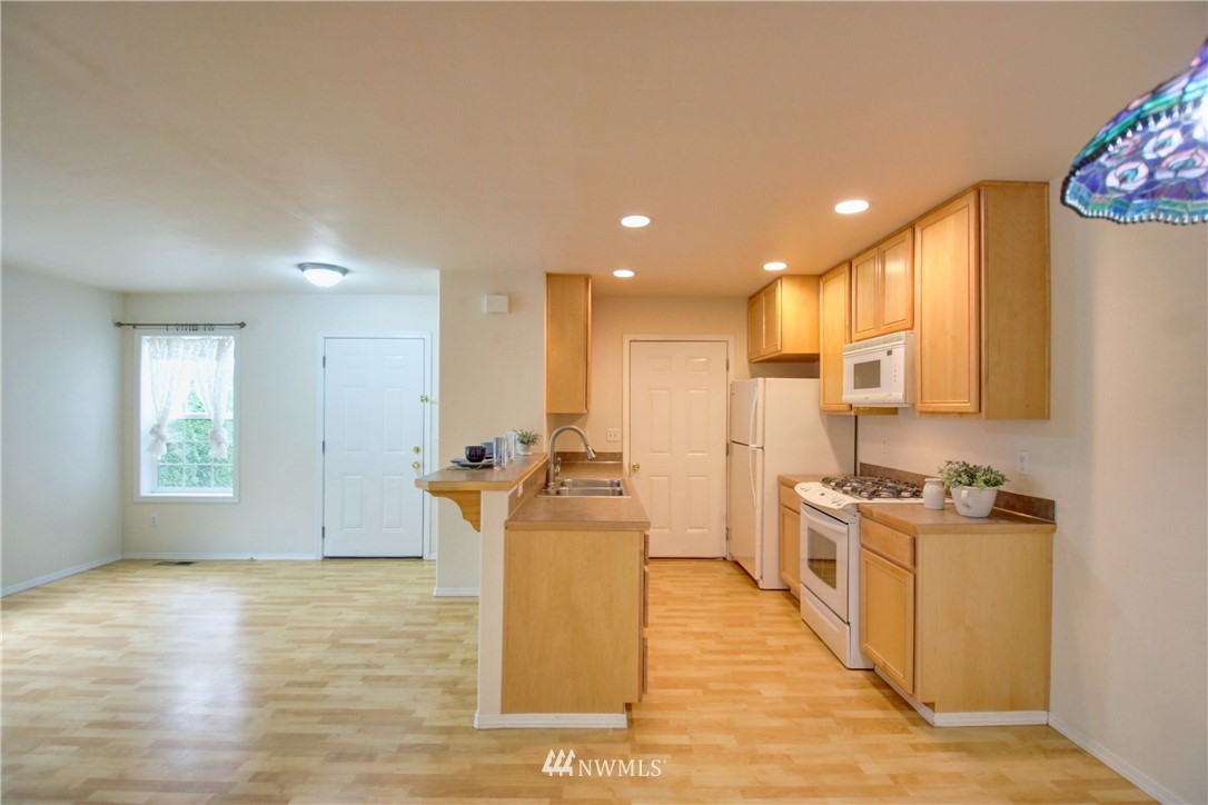 885 Cook Road, Unit 6 Sedro-Woolley, WA 98284 - Photo 4 of 31 a view of a kitchen with kitchen island a sink wooden floor and stainless steel appliances