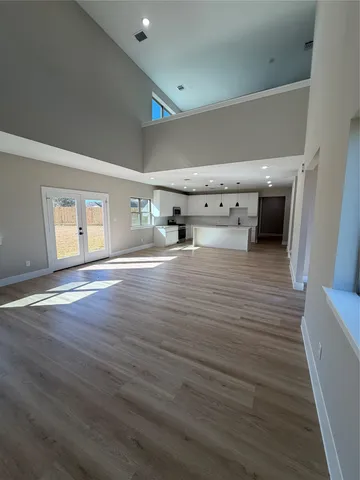 a big room with wooden floor and windows