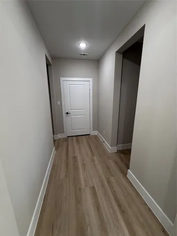 a view of a hallway with wooden floor