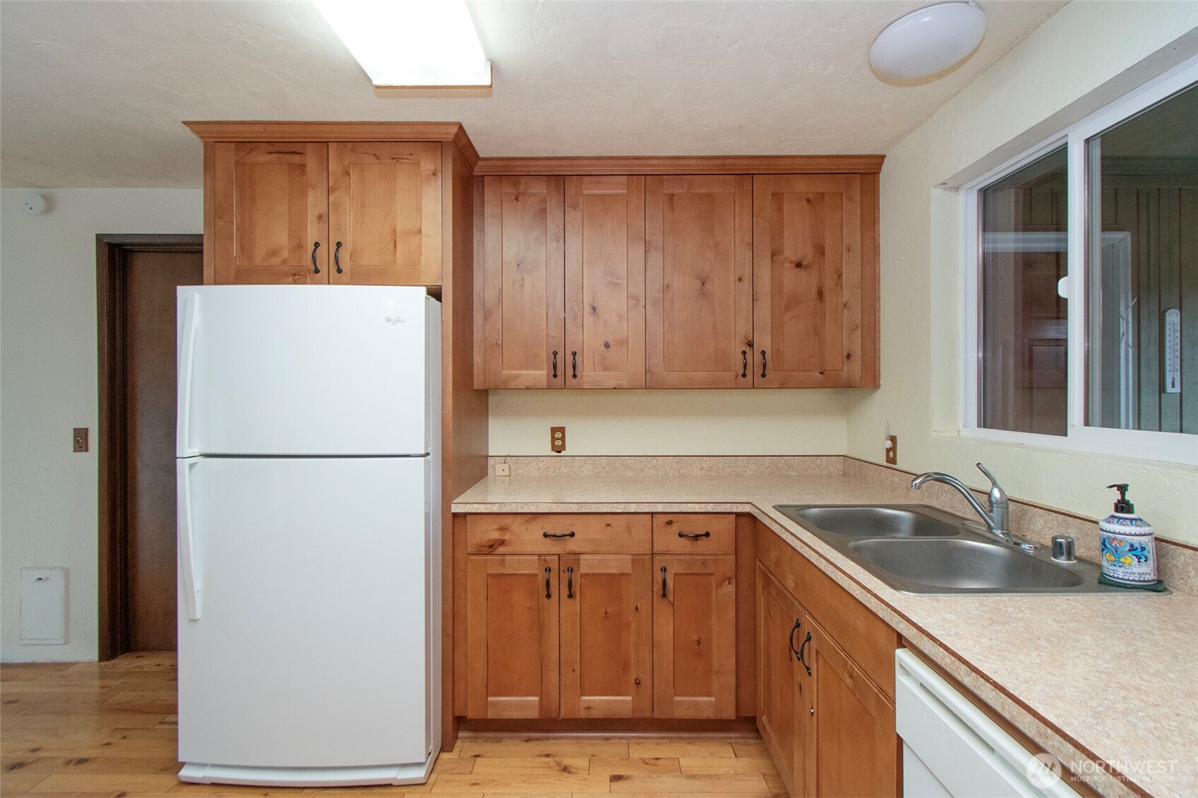 62 Hogback Road Sequim, WA 98382 - Photo 14 of 40 a white refrigerator freezer sitting inside of a kitchen with stainless steel appliances granite countertop wooden cabinets and a sink