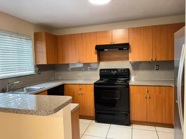 a kitchen with granite countertop a sink stove and cabinets
