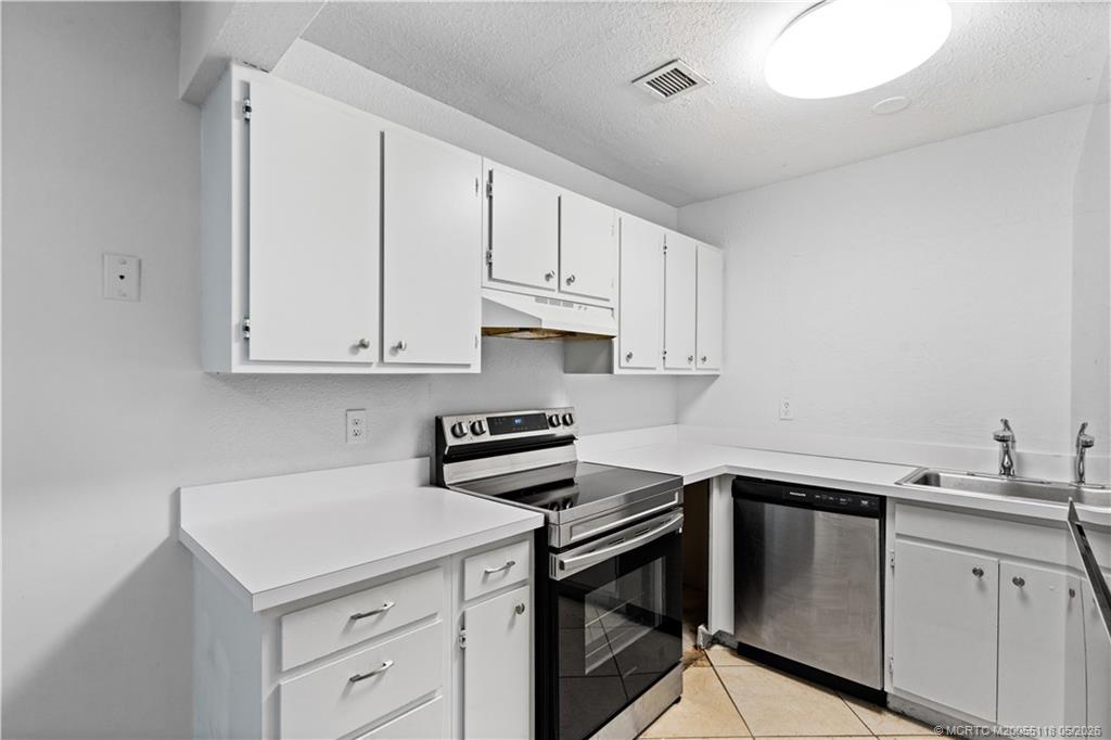 2118 Southeast Edler Drive, Unit B Stuart, FL 34994 - Photo 2 of 20 a kitchen with stainless steel appliances granite countertop a sink stove and cabinets
