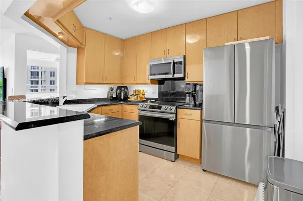 a kitchen with a refrigerator a sink a stove a microwave and cabinets