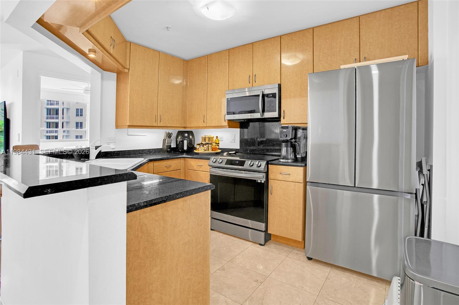 801 Brickell Key Boulevard, Unit 907 Miami, FL 33131 - Photo 12 of 53 a kitchen with a refrigerator a sink a stove a microwave and cabinets