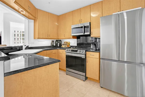 a kitchen with granite countertop a sink stove and refrigerator