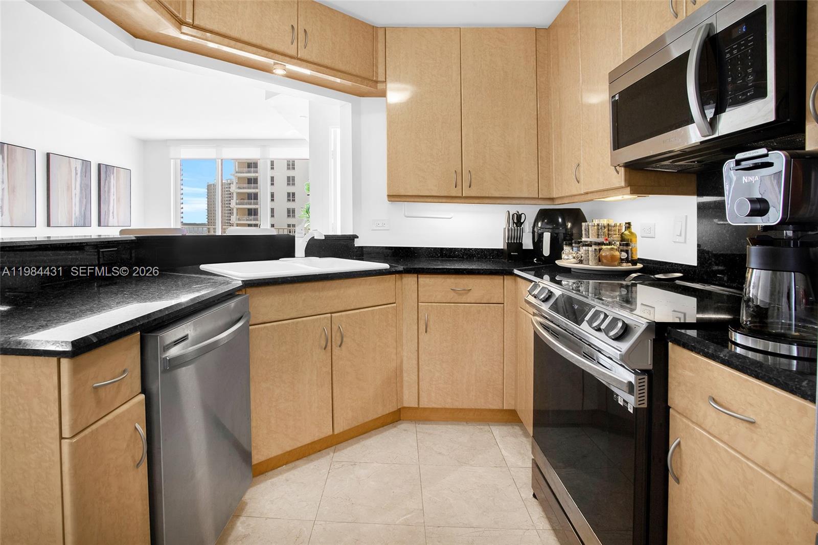 801 Brickell Key Boulevard, Unit 907 Miami, FL 33131 - Photo 14 of 53 a kitchen with stainless steel appliances granite countertop a sink stove top oven and cabinets