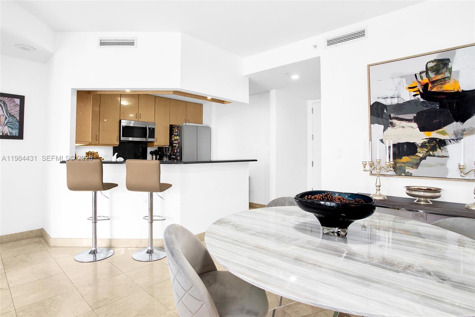 801 Brickell Key Boulevard, Unit 907 Miami, FL 33131 - Photo 22 of 53 a kitchen with a dining table and chairs