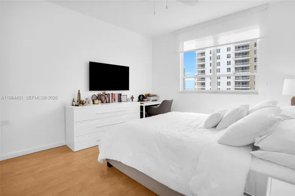 a bedroom with bed and wall painting with wooden floor