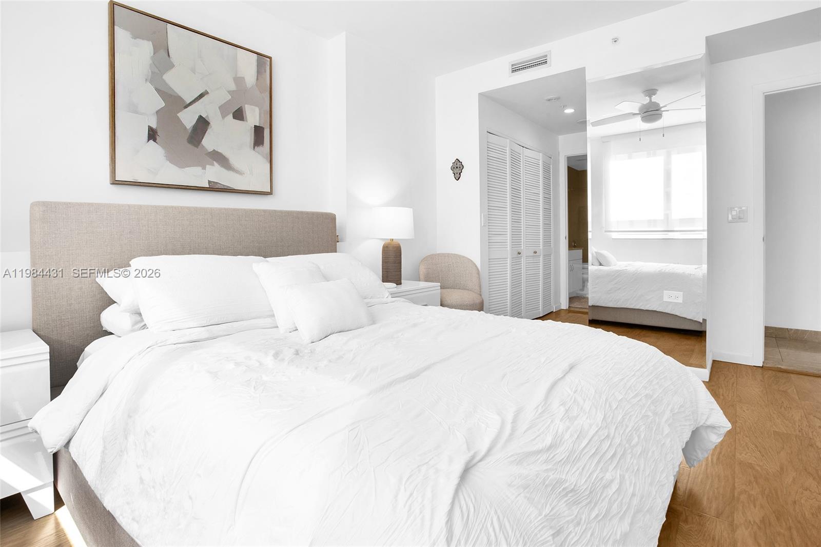 801 Brickell Key Boulevard, Unit 907 Miami, FL 33131 - Photo 25 of 53 a bedroom with bed and wall painting with wooden floor