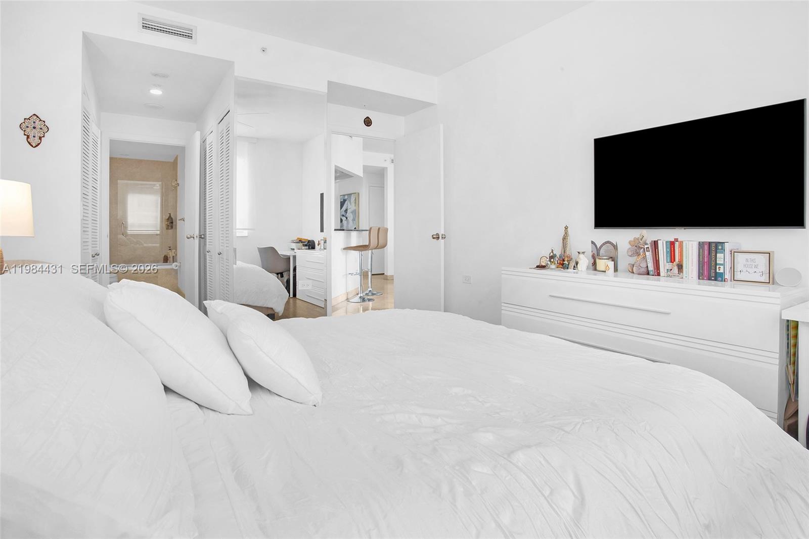 801 Brickell Key Boulevard, Unit 907 Miami, FL 33131 - Photo 26 of 53 a bedroom with a bed and a flat screen tv