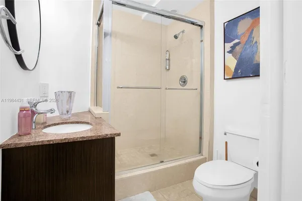 a bathroom with a granite countertop sink a toilet and shower