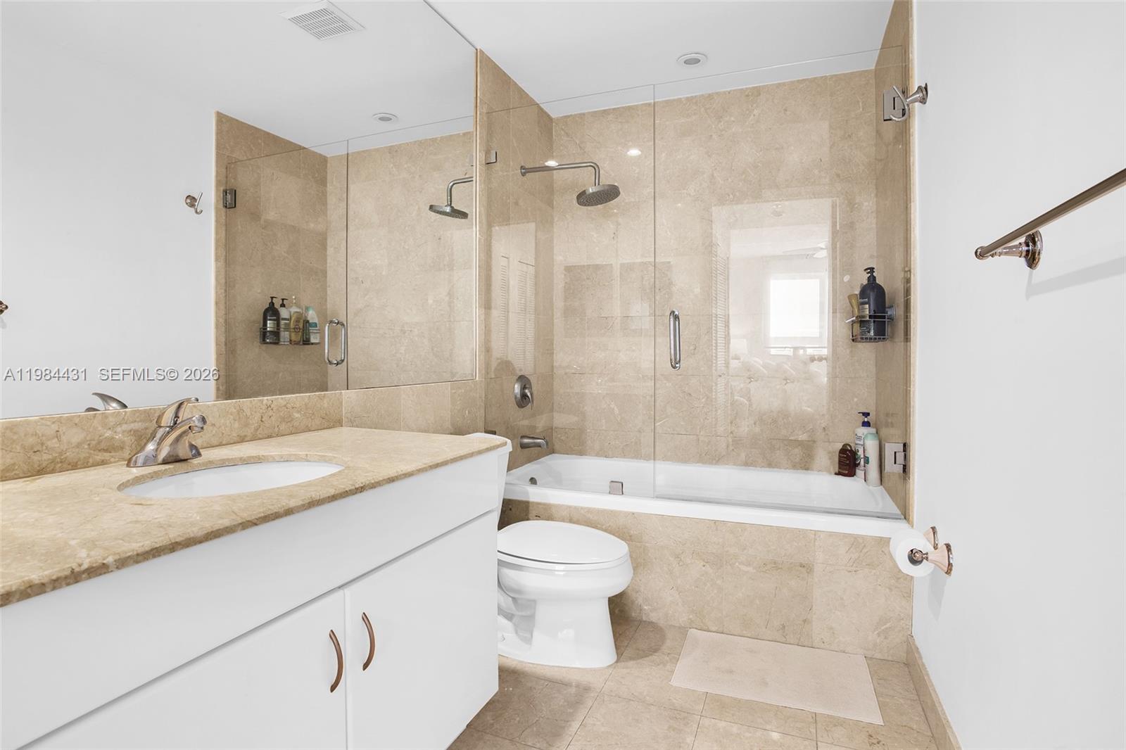 801 Brickell Key Boulevard, Unit 907 Miami, FL 33131 - Photo 30 of 53 a bathroom with a granite countertop sink a toilet and shower