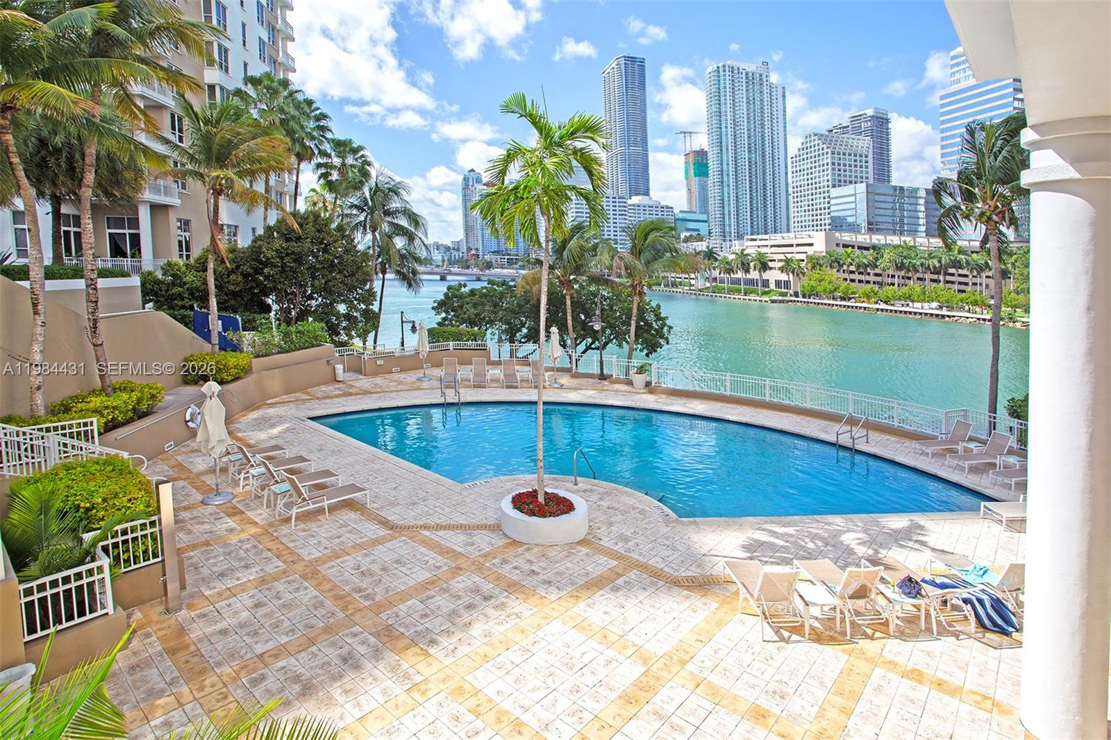 801 Brickell Key Boulevard, Unit 907 Miami, FL 33131 - Photo 33 of 53 a view of a swimming pool with a lounge chairs
