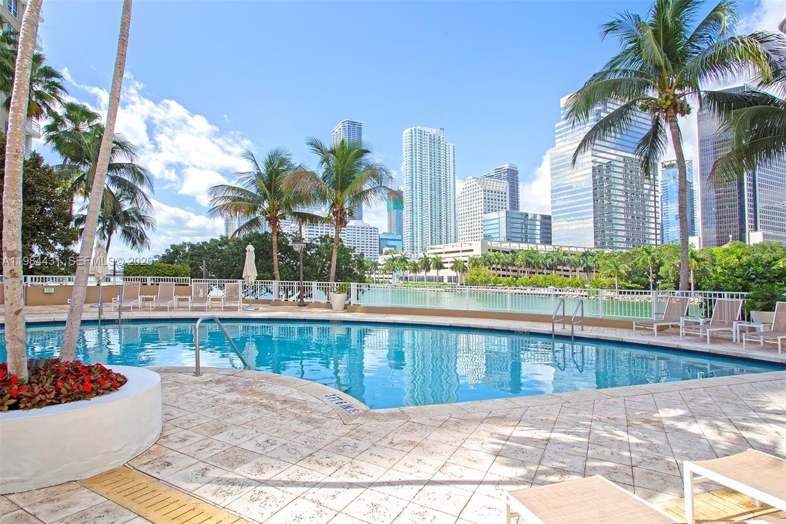 801 Brickell Key Boulevard, Unit 907 Miami, FL 33131 - Photo 35 of 53 a view of a swimming pool with a lounge chair