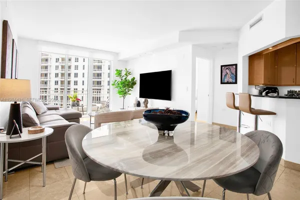 a living room with furniture a flat screen tv and a large window