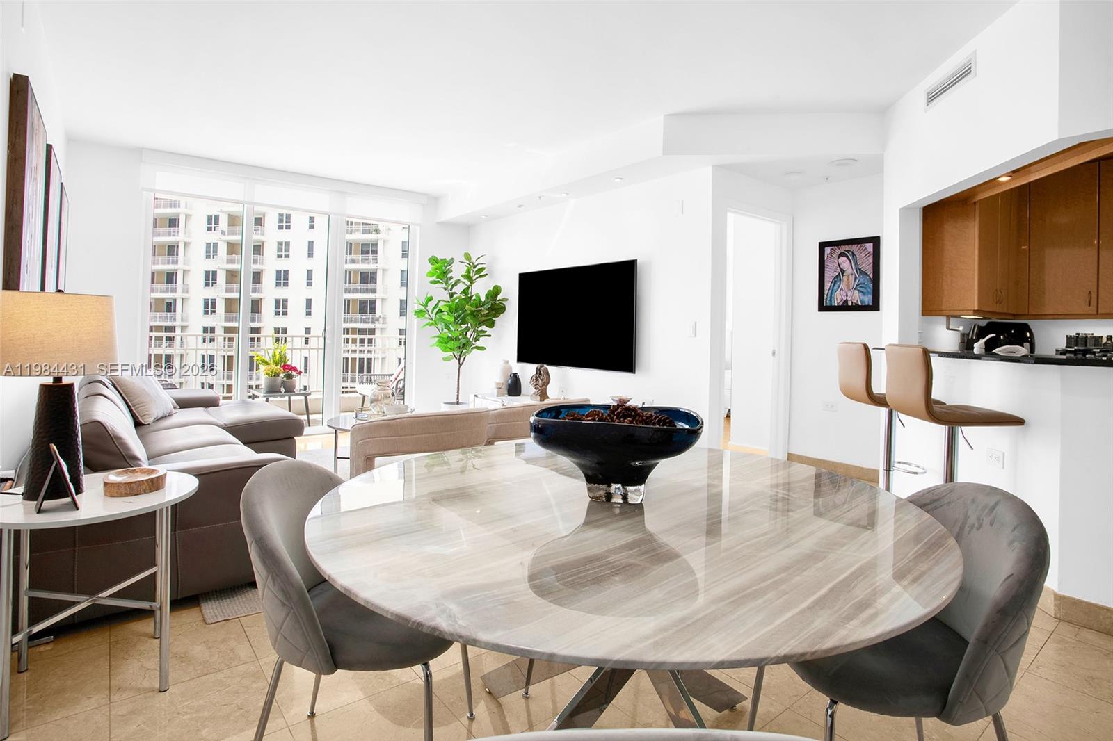 801 Brickell Key Boulevard, Unit 907 Miami, FL 33131 - Photo 4 of 53 a living room with furniture a flat screen tv and a large window