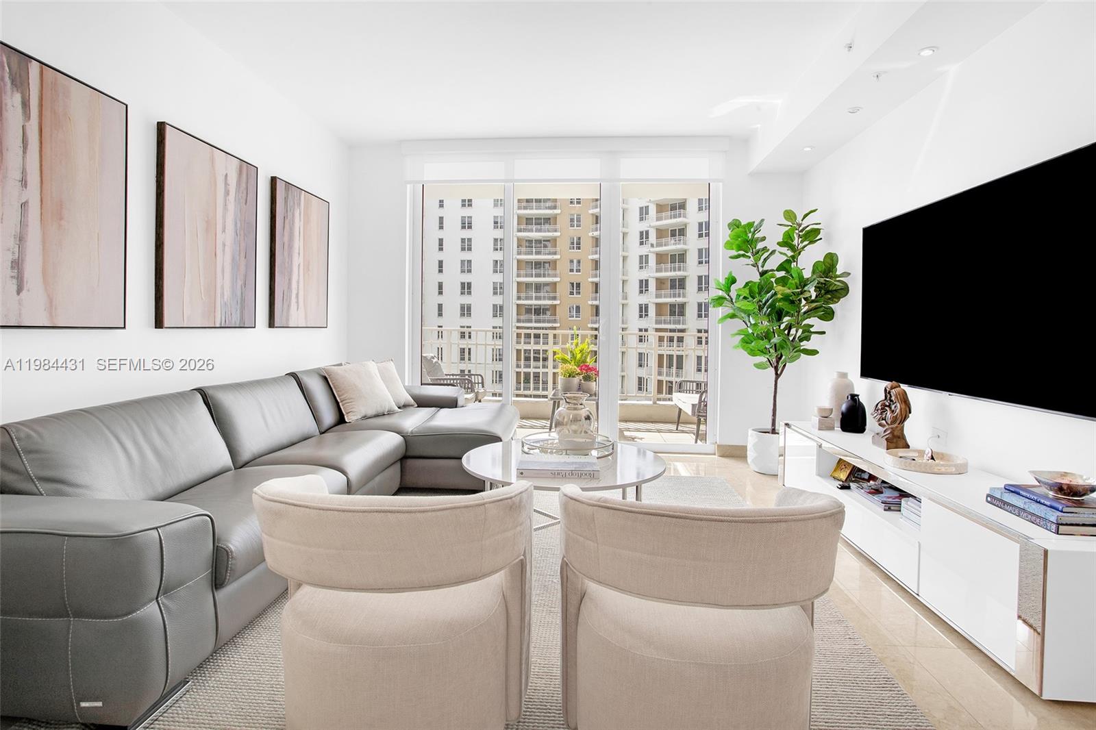 801 Brickell Key Boulevard, Unit 907 Miami, FL 33131 - Photo 7 of 53 a living room with furniture and a flat screen tv