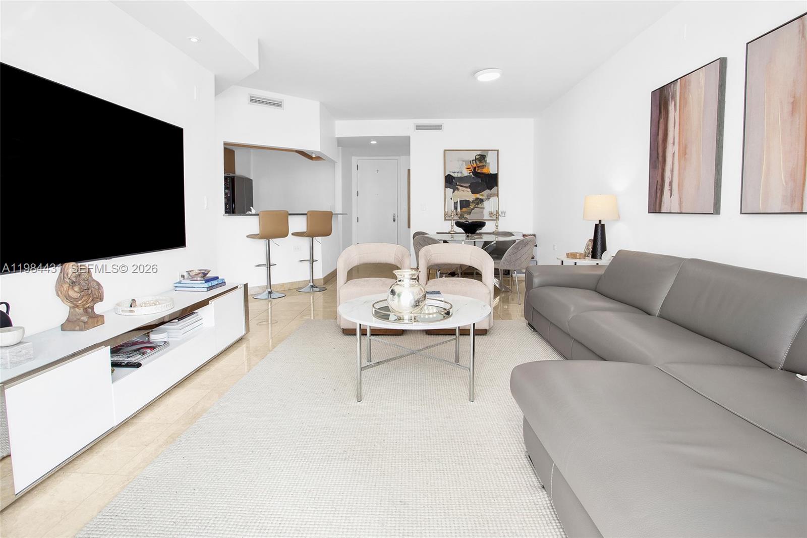 801 Brickell Key Boulevard, Unit 907 Miami, FL 33131 - Photo 10 of 53 a living room with furniture and a flat screen tv
