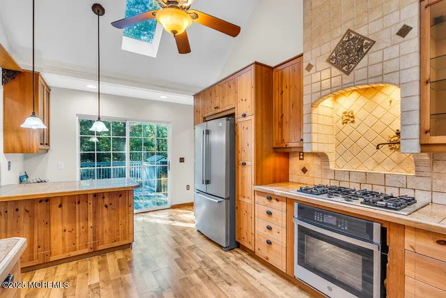 a kitchen with stainless steel appliances granite countertop a refrigerator and a stove top oven
