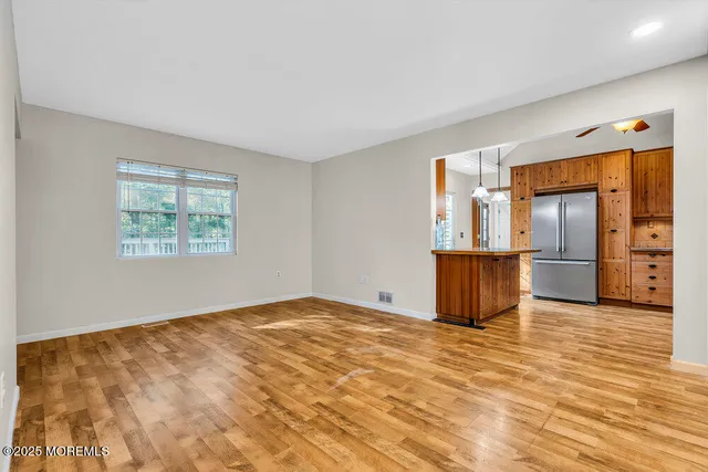 a view of a kitchen with wooden floor electronic appliances and windows