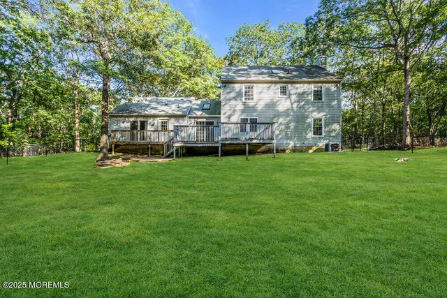 a view of a house with a big yard and large trees
