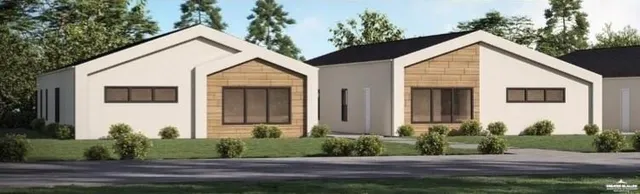 a view of a white house next to a yard