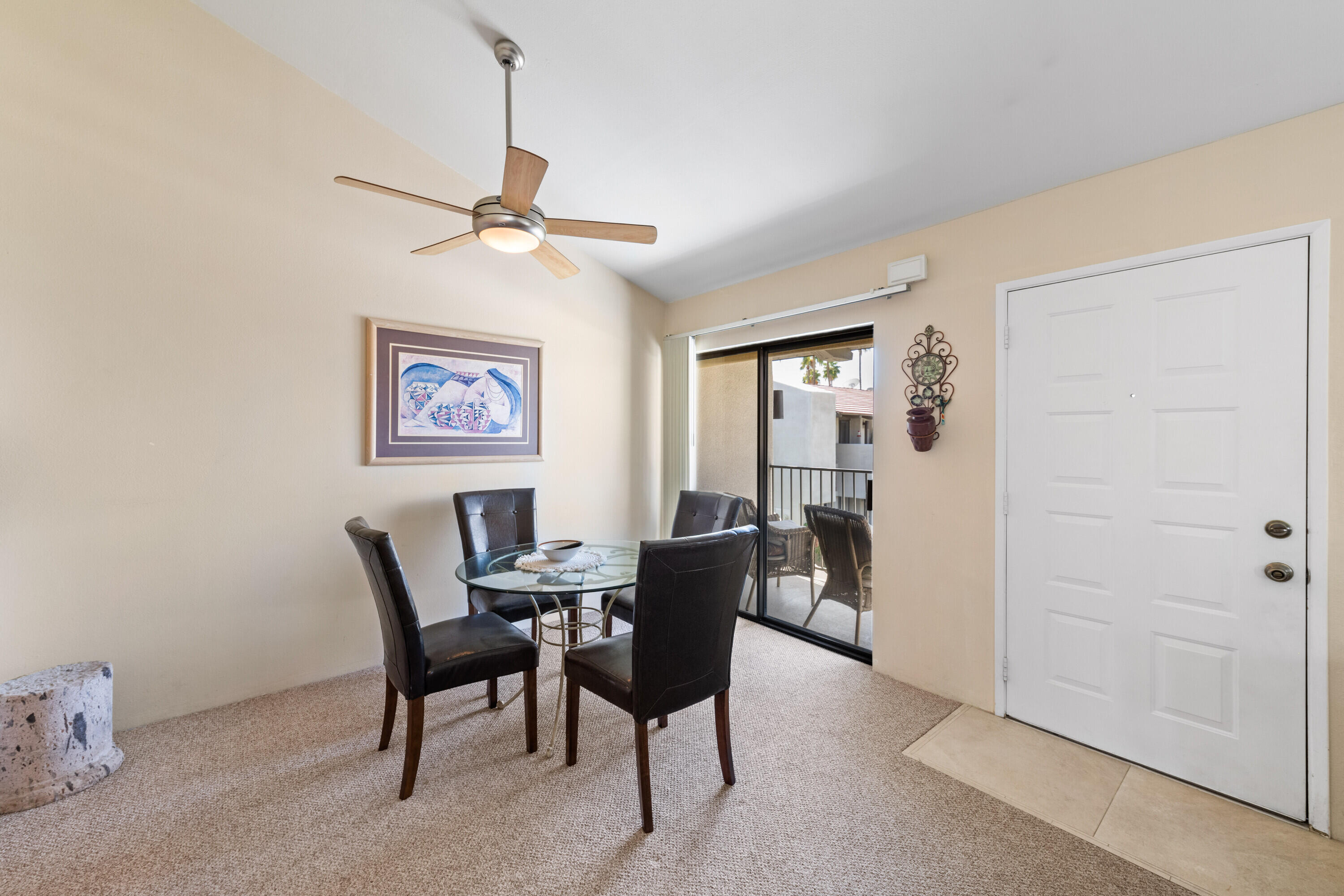 1150 East Amado Road, Unit 20C2 Palm Springs, CA 92262 - Photo 13 of 14 a dining room with furniture and a chandelier fan