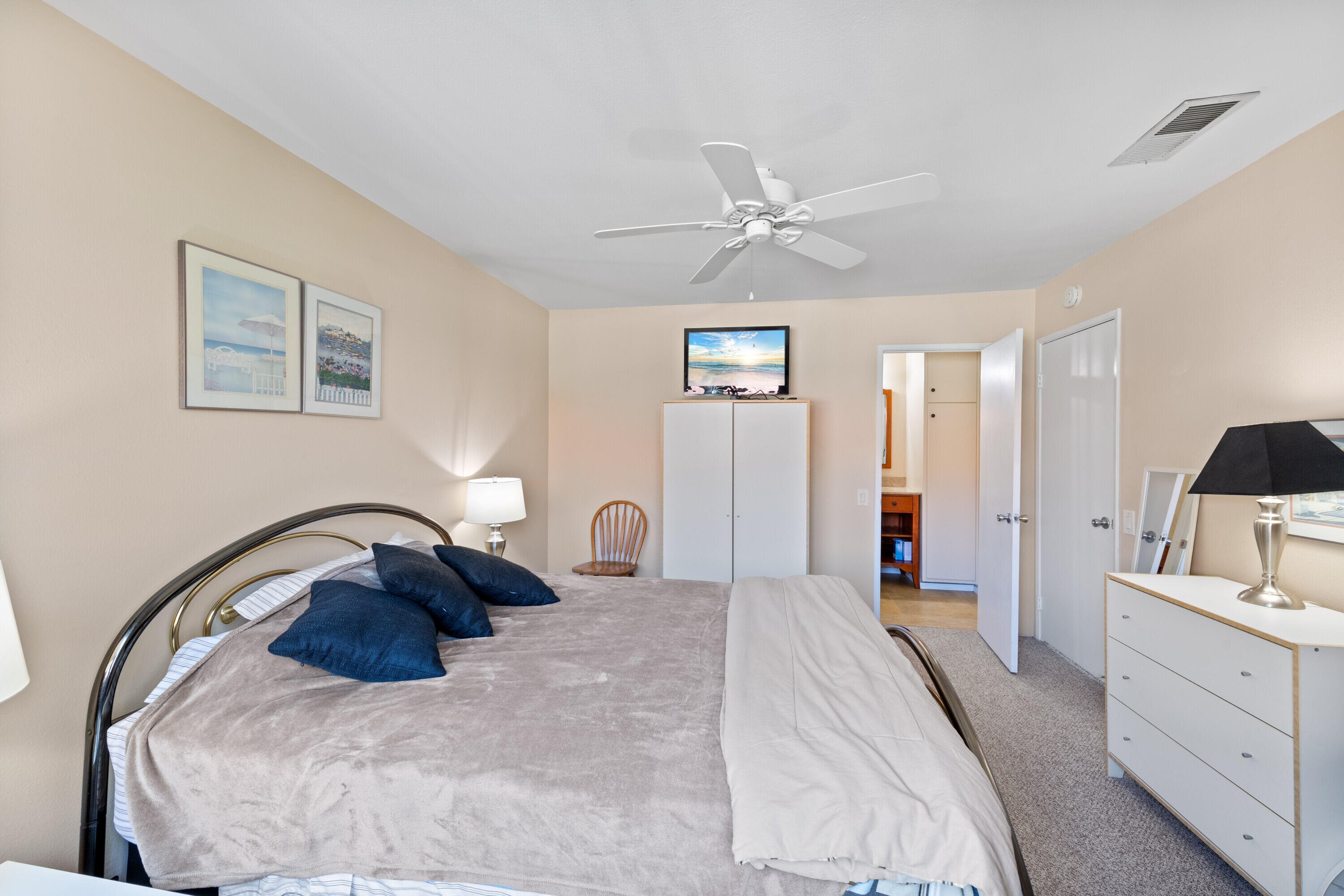 1150 East Amado Road, Unit 20C2 Palm Springs, CA 92262 - Photo 10 of 14 a bedroom with a bed and a chandelier