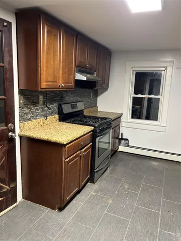 a kitchen with stainless steel appliances granite countertop a refrigerator a stove and a sink