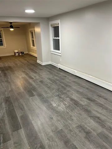 a view of an empty room with a window and a fireplace