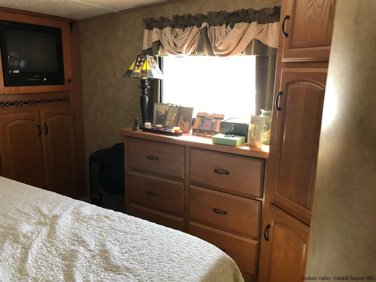 39 Travis Boulevard Catskill, NY 12414 - Photo 18 of 20 a bedroom with a bed and a flat tv screen on dresser