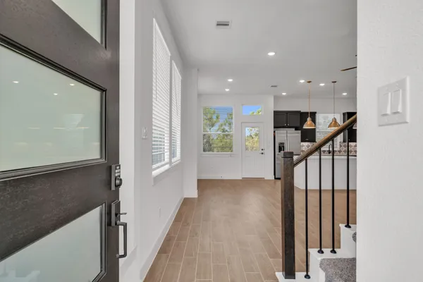a view of a hallway with wooden floor and staircase