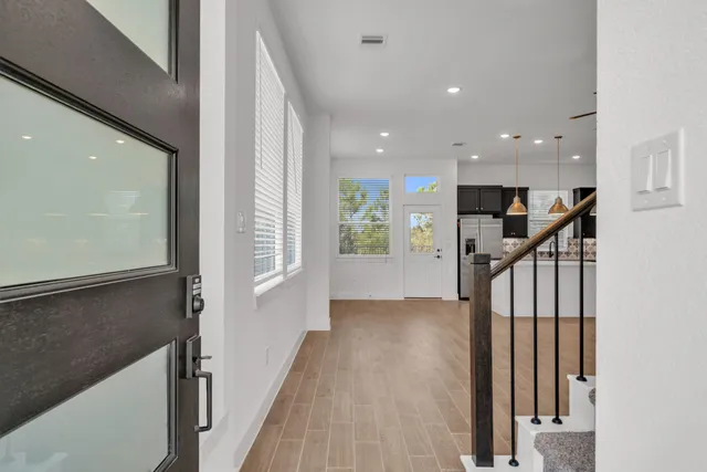 a view of a hallway with wooden floor and staircase