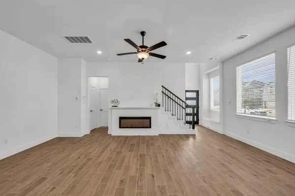 a view of empty room with wooden floor and a ceiling fan