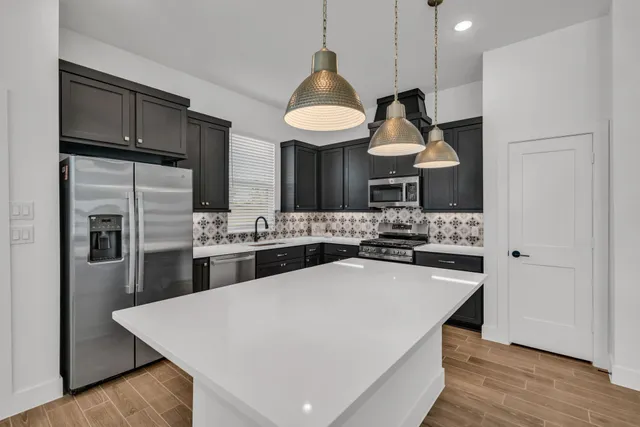 a kitchen with stainless steel appliances a stove refrigerator and wooden cabinets