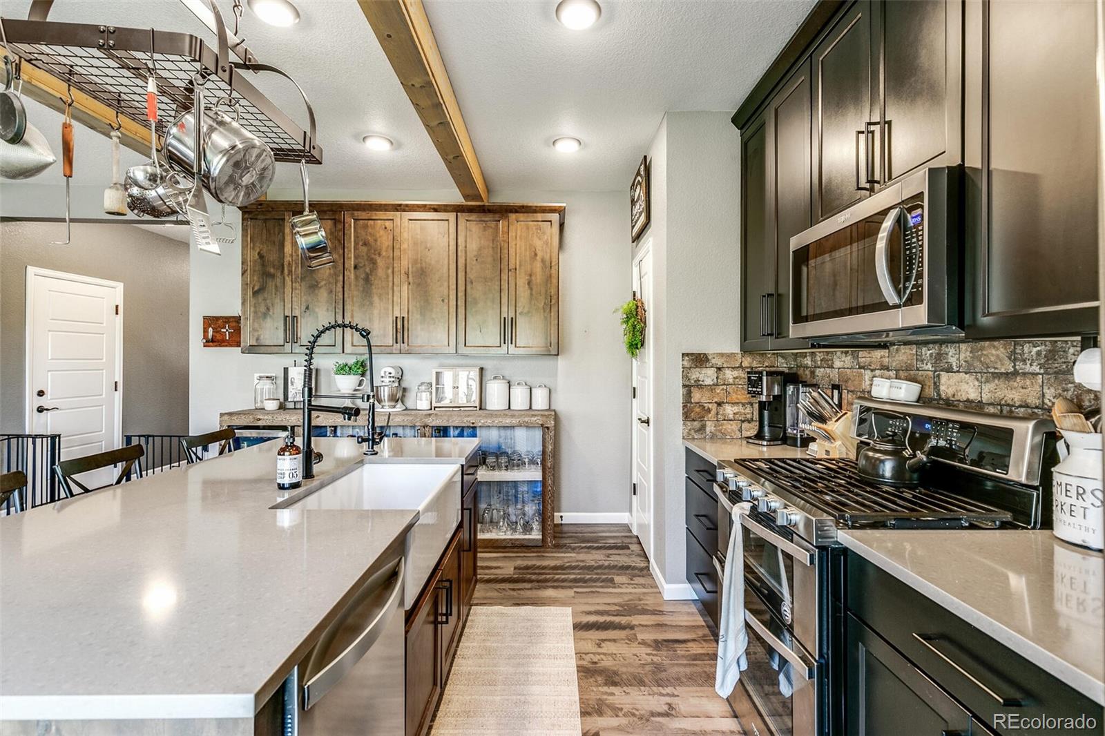 42891 Hawktree Circle Elizabeth, CO 80107 - Photo 12 of 39 a kitchen with stainless steel appliances granite countertop a sink a stove and microwave